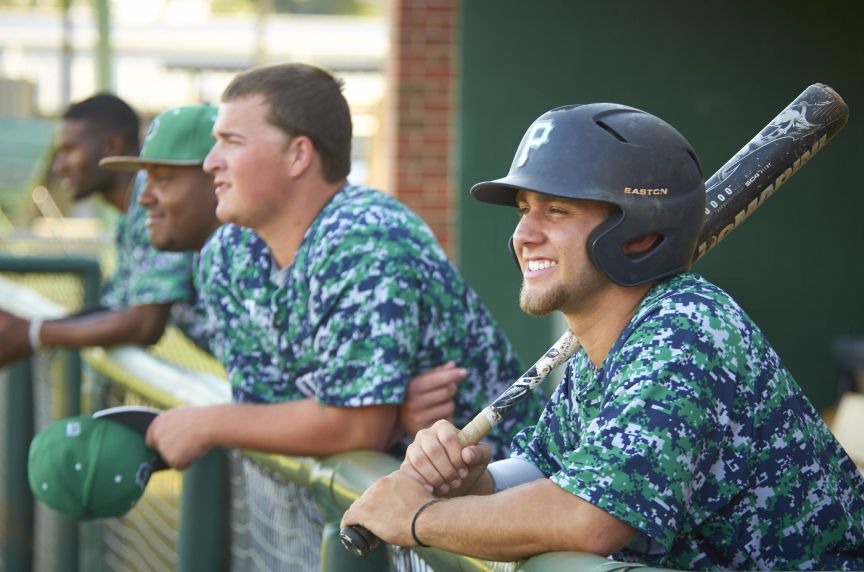 Baseball players in team uniforms at the dugout during a game, showcasing sports, fitness, and recre.