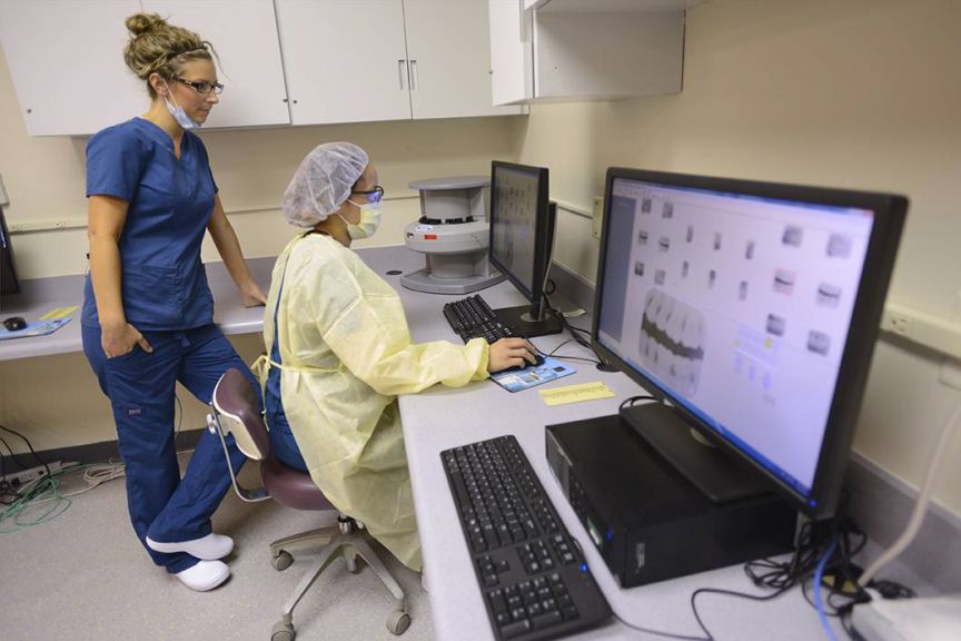 Medical professionals using digital imaging equipment in a clinical environment.