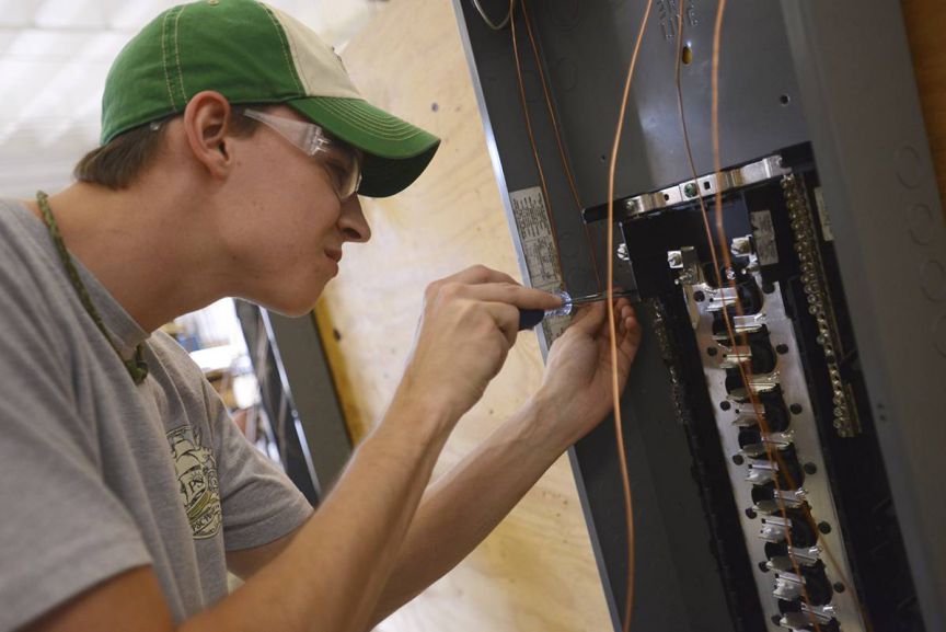 Electrical technician working on electrical panel for hands-on training.