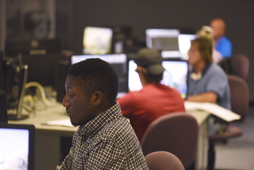 Accessible computer science classroom with diverse students working on coding projects at Pensacola.