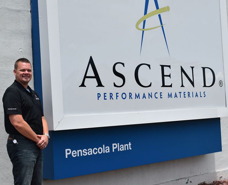 Manufacturing plant technician at Pensacola State College Manufacturing technician standing next to Ascend Performance Materials sign at Pensacola Plant.