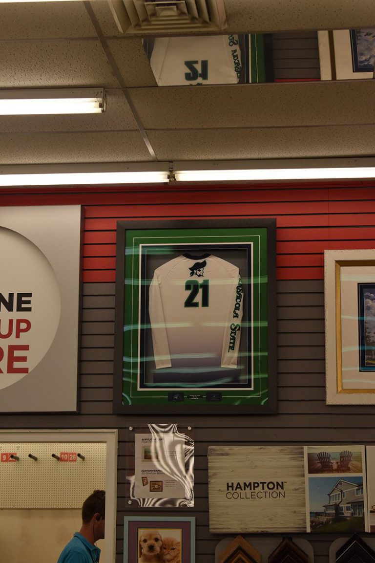 Brightly lit display showcasing a framed jersey with the number 21, part of a pirate-themed treasure.