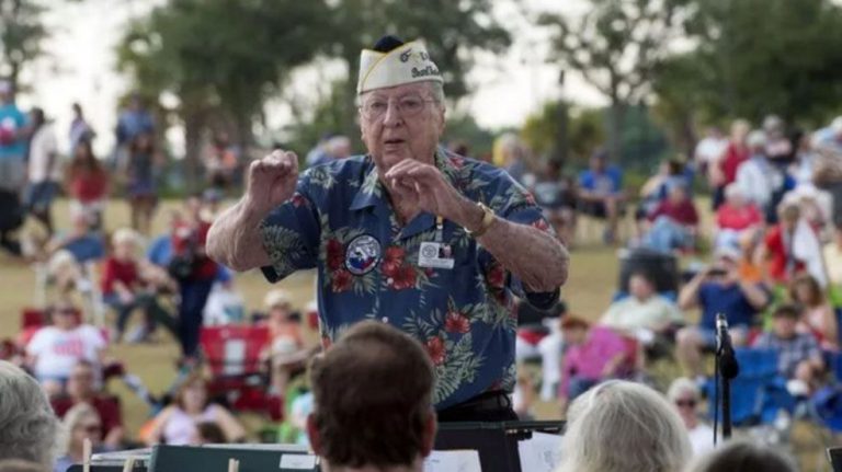 An elderly Pearl Harbor survivor conducts a patriotic performance during Pensacola's Memorial Day ev.