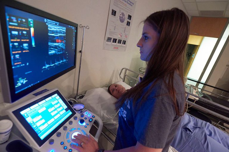 Ultrasound technician performing diagnostic imaging during a health career fair.