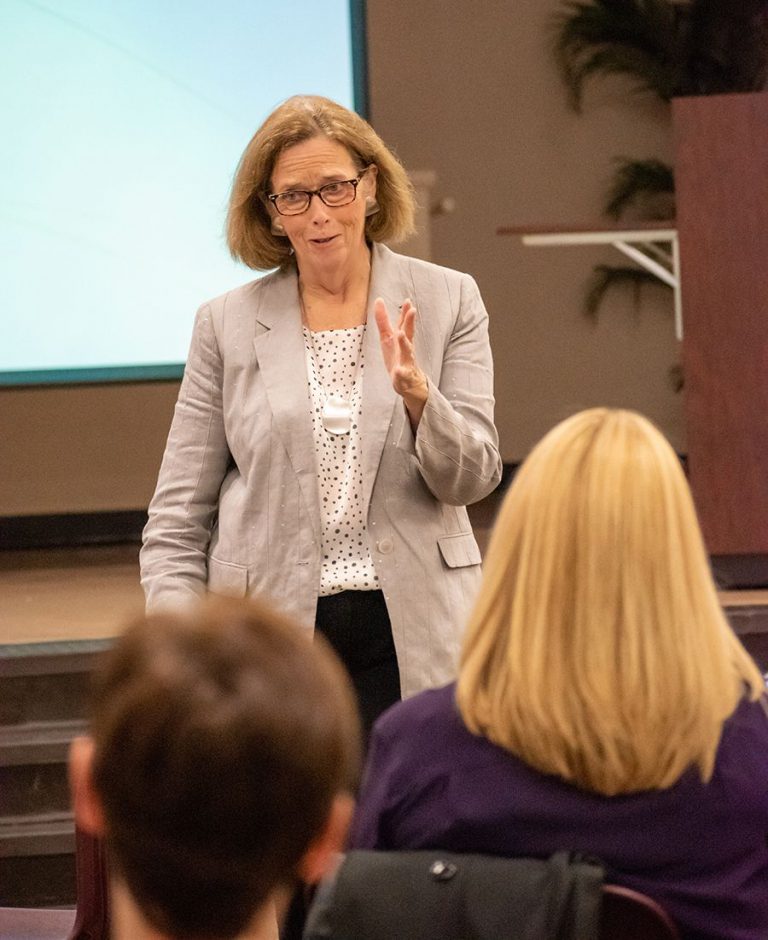 Woman speaker teaching nonprofit fundraising techniques to charitable organization leaders.