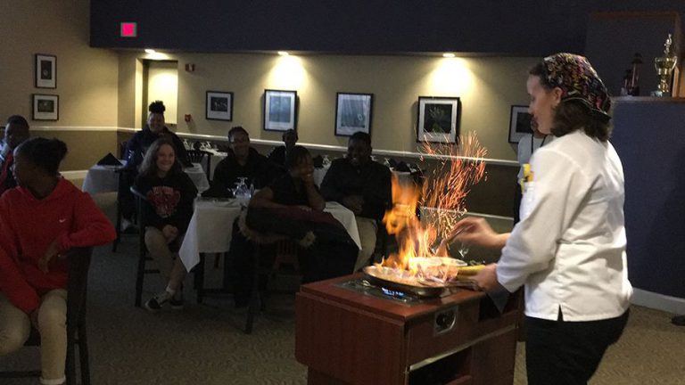 Culinary students at PSC showcase Bananas Foster to Dixon School visitors.