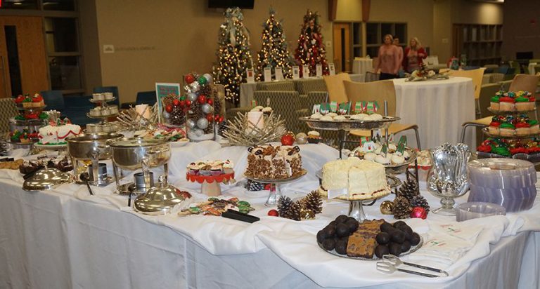 Festive holiday dessert table featuring cakes, cookies, and treats at Pensacola State College Milton.