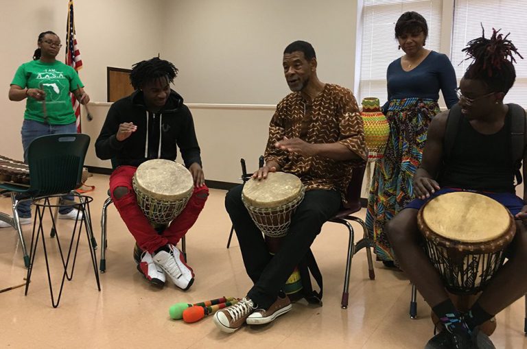 Diverse students participate in African drumming workshop at Pensacola State College.