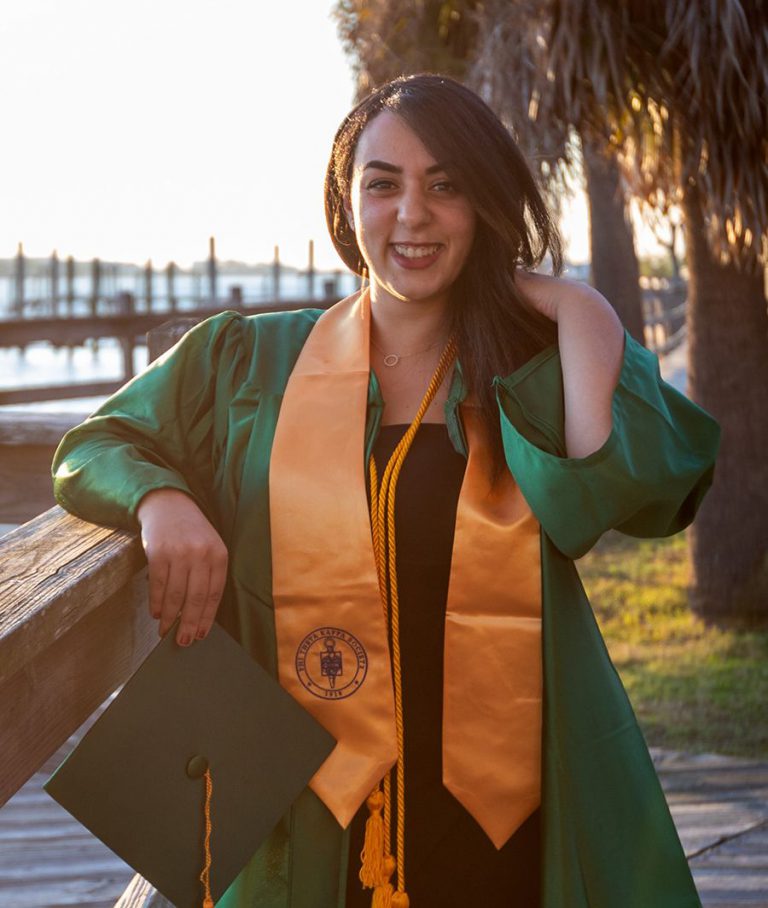 Graduate with cap and gown celebrating academic achievement at Pensacola State College.