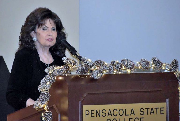 High-resolution image of a woman speaking at a Pensacola State College event supporting student scho.