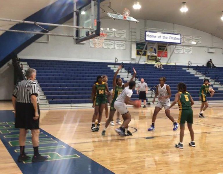 High school basketball game at Pensacola State College gymnasium with student athletes in action.