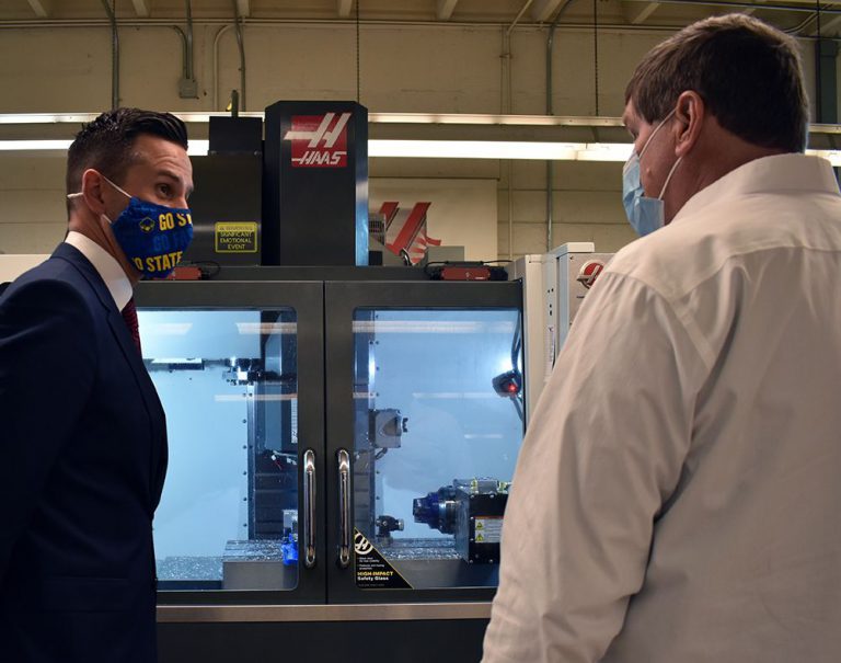 Highly skilled instructors discuss advanced manufacturing training with students.