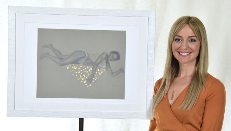 Alaina Plowdrey, new Visual Arts Department head at Pensacola State College, with artwork display.