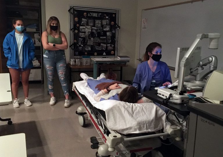 Healthcare students practicing patient care skills in a simulation lab at Pensacola State College.