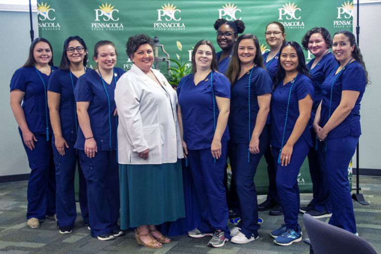 Vet Tech students in blue scrubs with instructor at Pensacola State College.