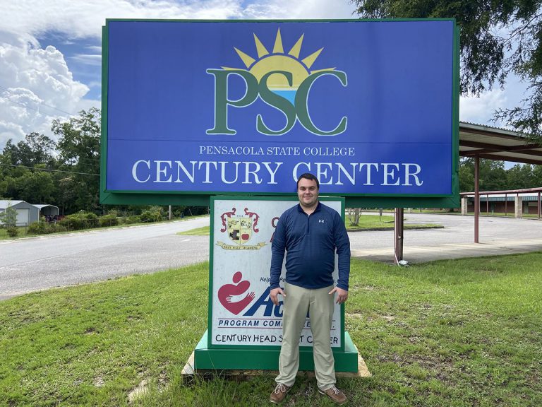 Alex Andrews, the new Century Center coordinator, standing in front of Pensacola State College's Cen.