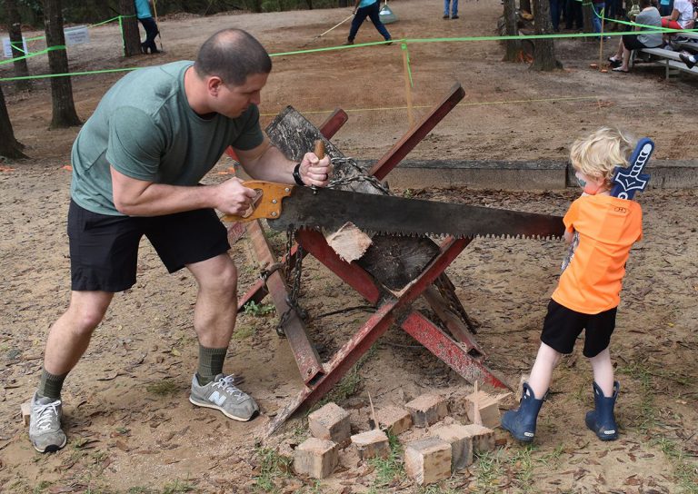 Man sawing wood at Pensacola State’s Lumberjack Festival event.