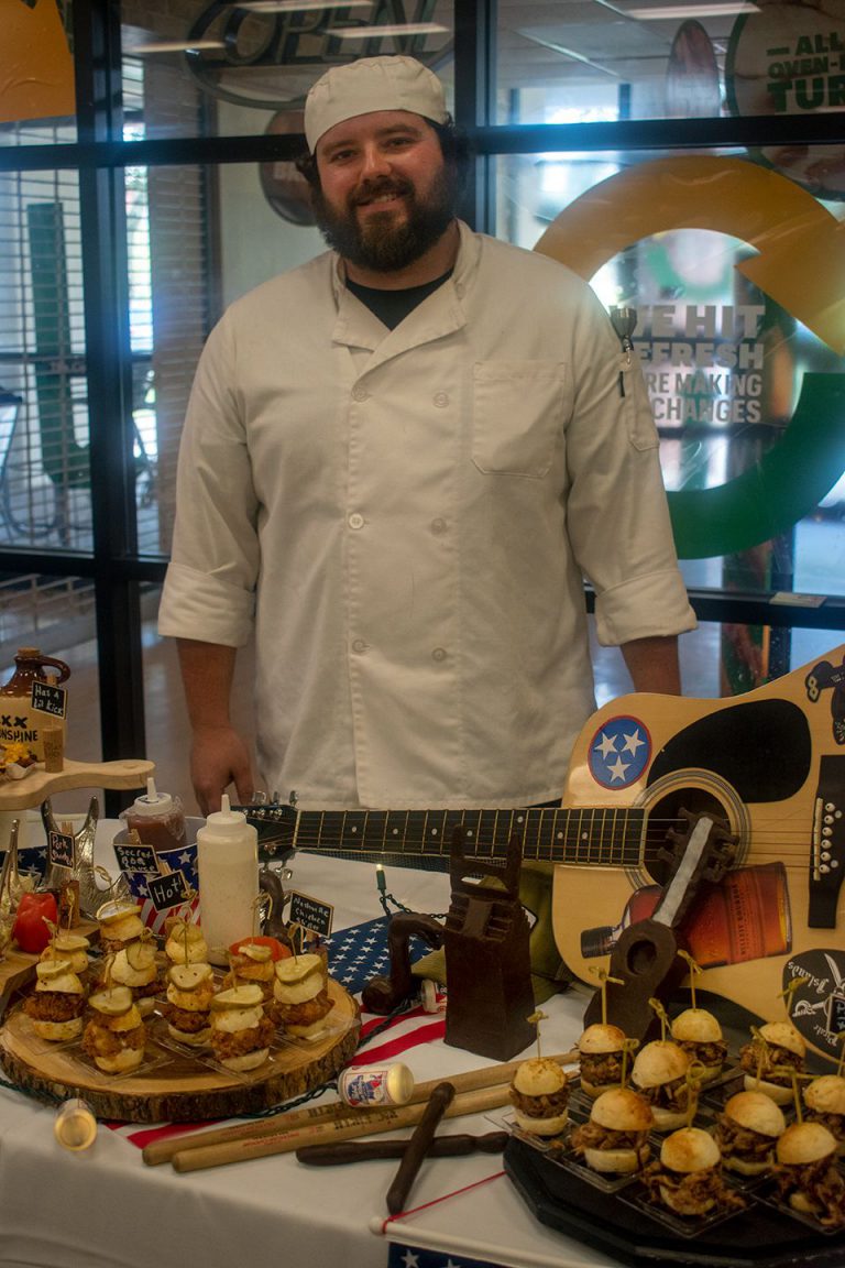 Garde Manger culinary student showcasing skills during college celebration event.