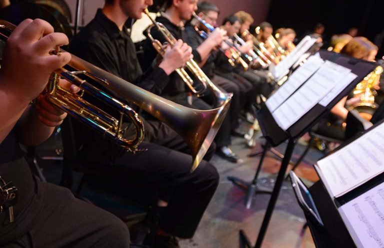 Music students playing saxophones in a college concert band performance at Pensacola State College. Ensemble of college musicians performing in a concert band at Pensacola State College.
