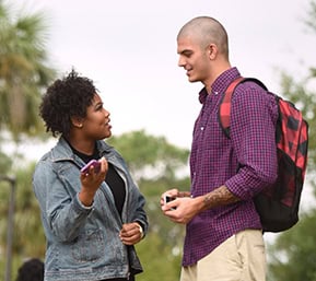 Students talking outdoors at Pensacola State College campus.