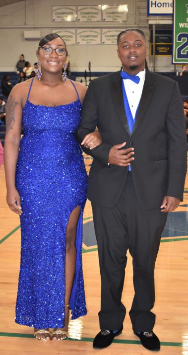 Smiling students in formal attire at the college's homecoming event.