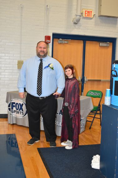 Smiling man and young woman in costume at college event.