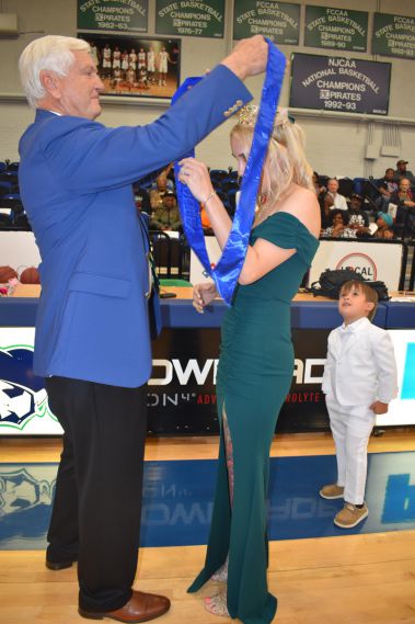 High school homecoming event with student receiving a medal at college sports event.