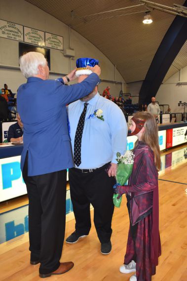 Senior man receiving a crown during homecoming event.