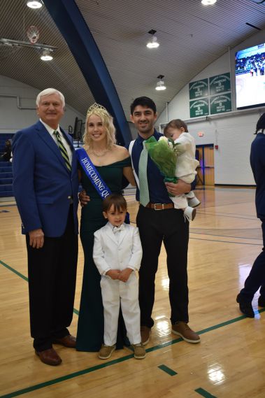 Happy family celebrating graduation at Pensacola State College Homecoming event.