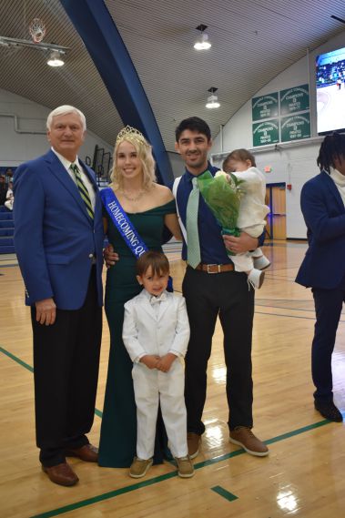 Smiling students and family members at college homecoming event.