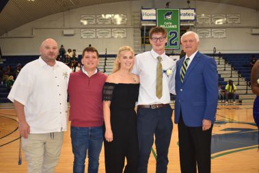 Smiling group of students and faculty celebrating Homecoming at Pensacola State College basketball g.