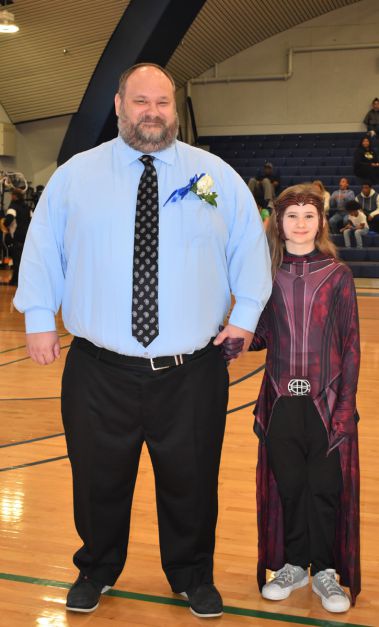 An image of a man and a young woman at a college graduation event, celebrating academic achievement.