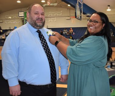 Happy students during college homecoming event at Pensacola State College gymnasium.