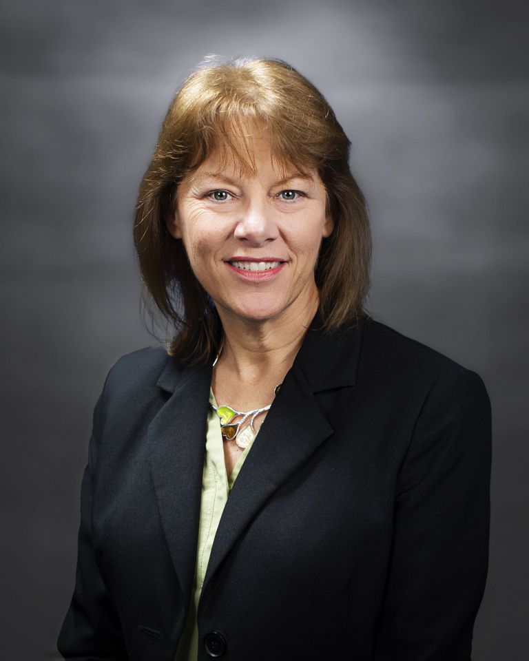 Woman in professional attire at nonprofit resource development workshop, Pensacola State College.