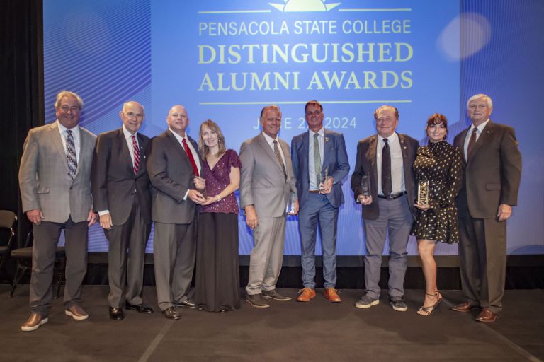 Group photo of 7 distinguished alumni and college officials at the 2024 Pensacola State College awar.