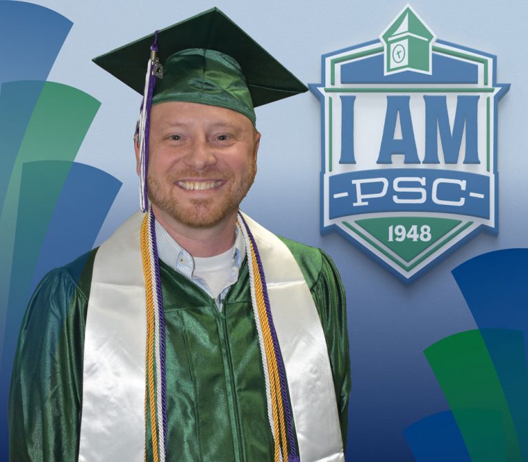 Optimized ALT text: Graduate in cap and gown celebrating at Pensacola State College with "I am PSC".
