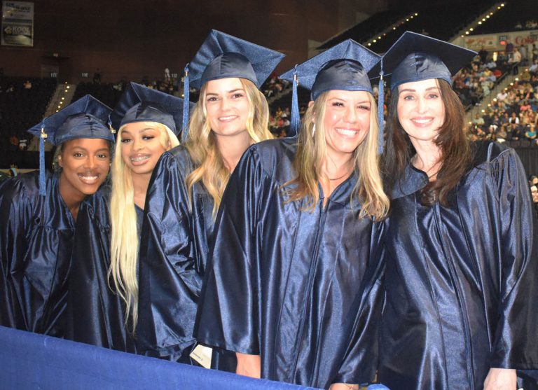 Graduates celebrating at Pensacola State College graduation ceremony Graduates in caps and gowns at Pensacola State College December graduation at Bay Center.