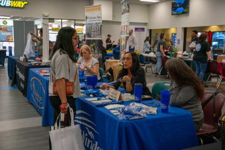 Students engaging at a Pensacola State CTE program fair promoting community and career opportunities.
