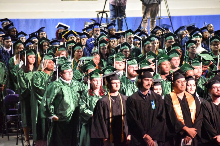 Pensacola State College graduation ceremony with students in caps and gowns at Bay Center.